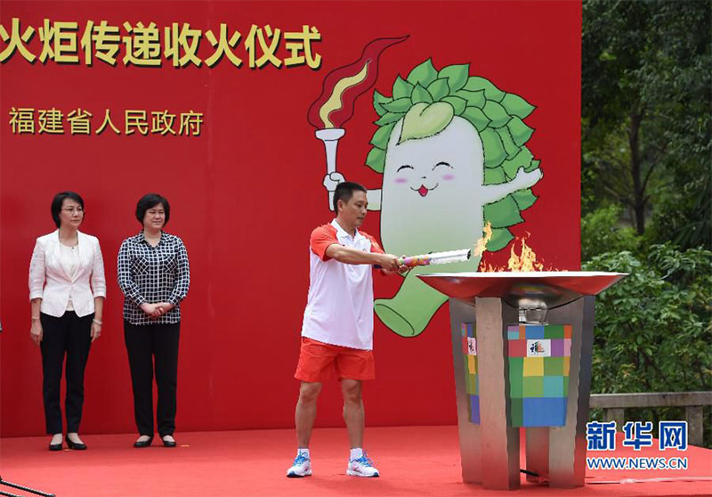 最后一棒火炬手、勞模代表鄭貞良點燃聖火盆。