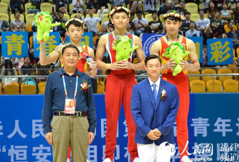 楊威為獲得青運會體操男子鞍馬前三名的選手頒獎並合影。李挺攝